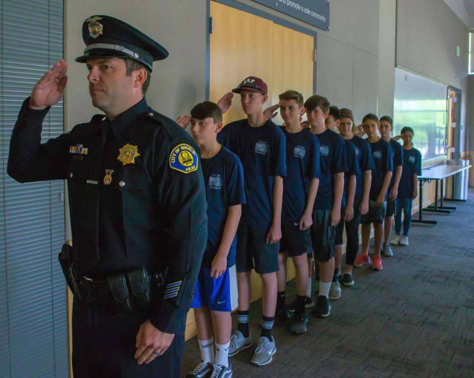 Officer Duckham leads a group of Junior Police Academy students in a salute during the summer of 2018.