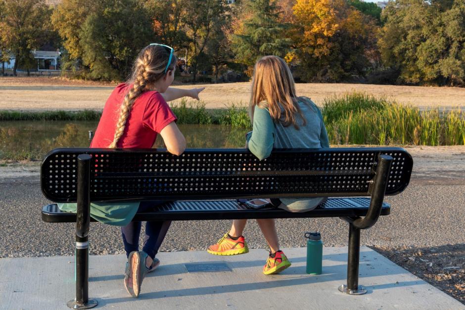 Two park-goers sit on one of the newly installed benches at Sunset Whitney Recreation Area