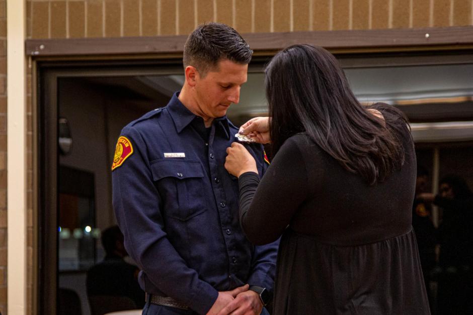 Firefighter recruit Jordan Poe is pinned by his wife Anna.