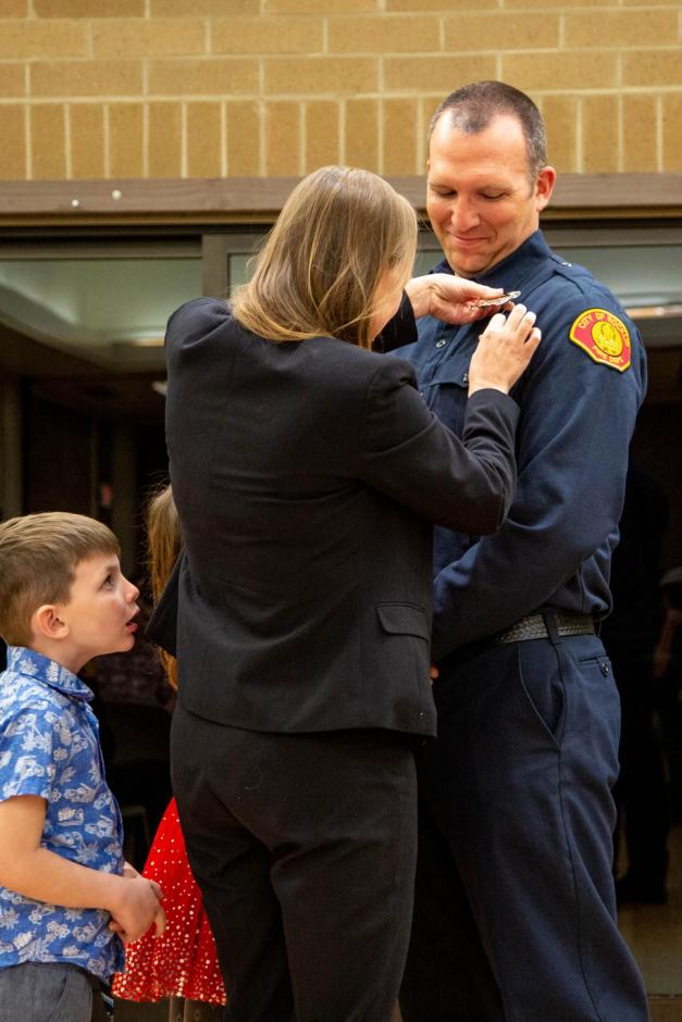 New firefighter recruit Kevin Stenson is pinned by his wife Jacqui, daughter Ryleigh, and son Tyler.