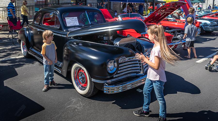 Children exploring the vintage cars at the Hot Chili Cool Cars annual event in Rocklin, CA