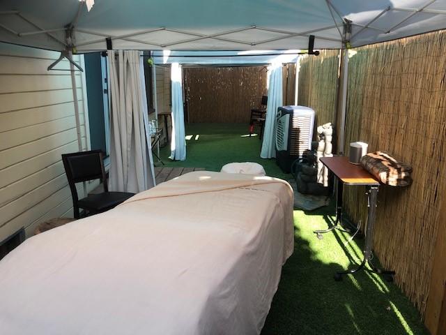 A massage table is ready for clients in Rejuven8's backyard.