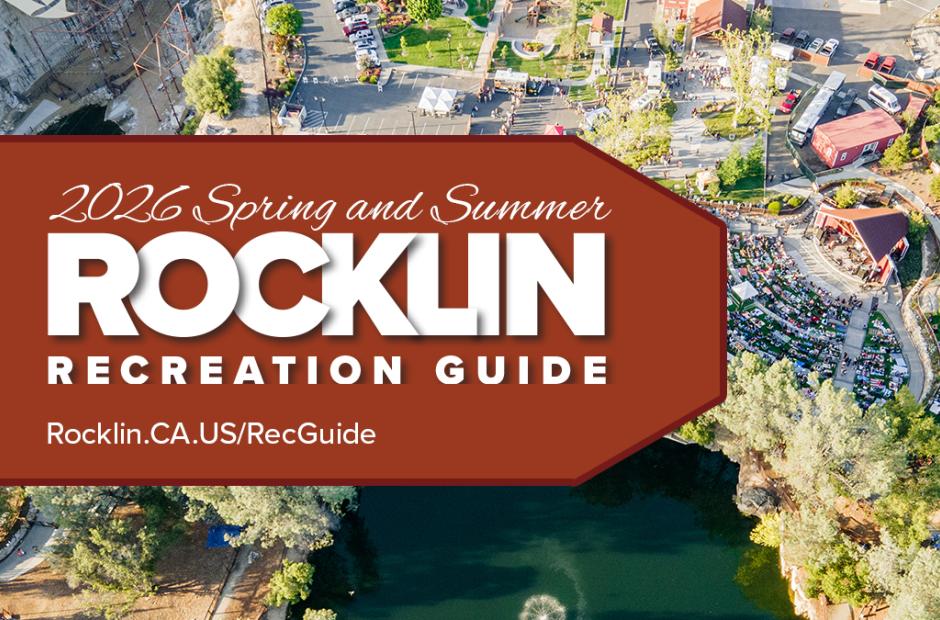 Promotional graphic for the 2026 Spring and Summer Rocklin Recreation Guide. The left side features a deep rust-red background with the City of Rocklin California logo at the top and large white text reading “2026 Spring and Summer Rocklin Recreation Guide.” At the bottom left, white text reads “Rocklin.CA.US/RecGuide.” The right side shows an aerial photo of Quarry Park Amphitheatre during a large outdoor event, with crowds seated on the lawn, surrounding trees, pathways, and parked cars visible. Overlaid on the aerial photo is a curved, page-turn style image of the printed Rocklin Recreation Guide, showing colorful program listings and photos, suggesting the guide opening or flipping pages.