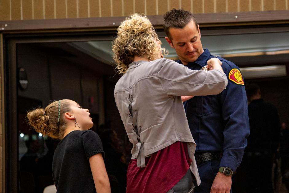 Firefighter recruit Chris Marson is pinned by his wife Alexis and daughter Selah.