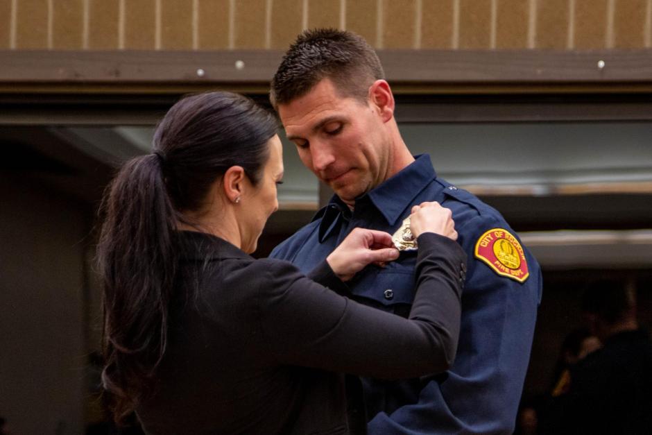 Firefighter recruit Erik Garside is pinned by his wife Amy.