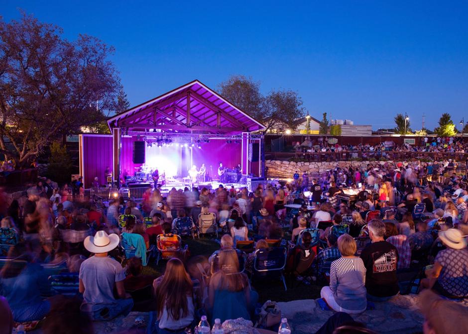 The Quarry Park Amphitheater lit up in purple lights at night.