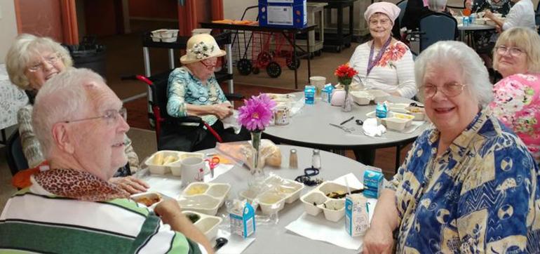 Seniors cheerfully taking part in a Seniors First-sponsored lunch